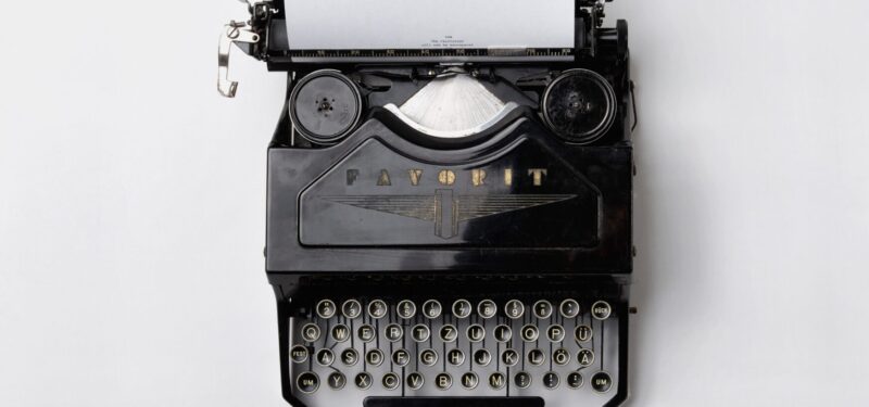 Does your email copy persuade or sell? black typewriter on white background