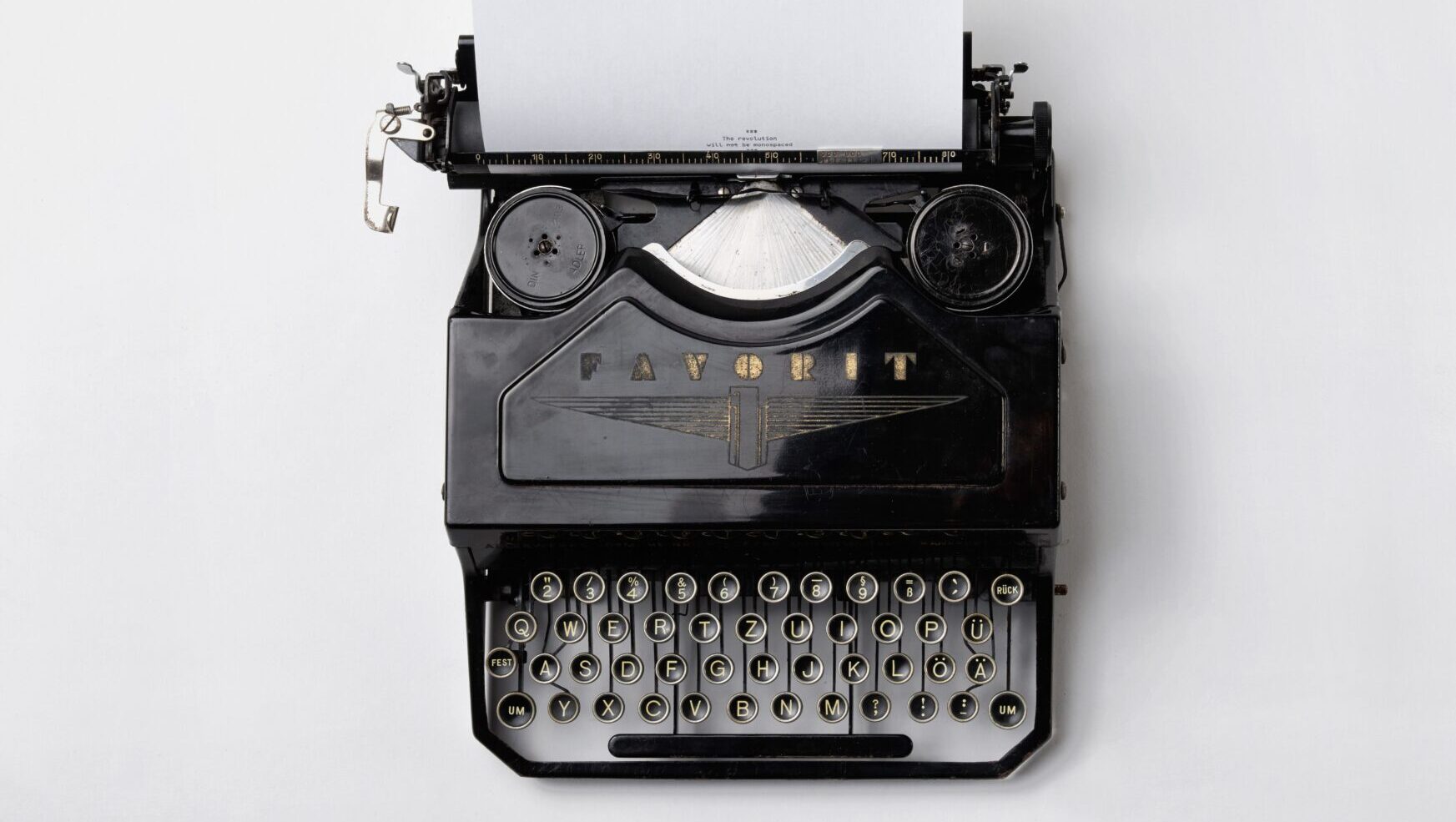 Does your email copy persuade or sell? black typewriter on white background